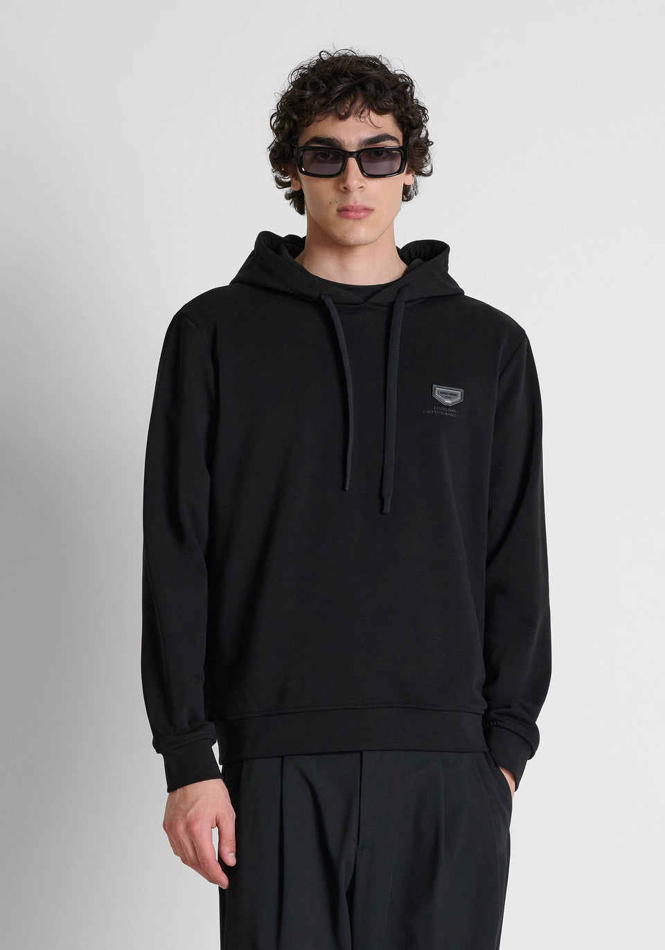 Black relaxed-fit hoodie in cotton fleece with metal plate on heart