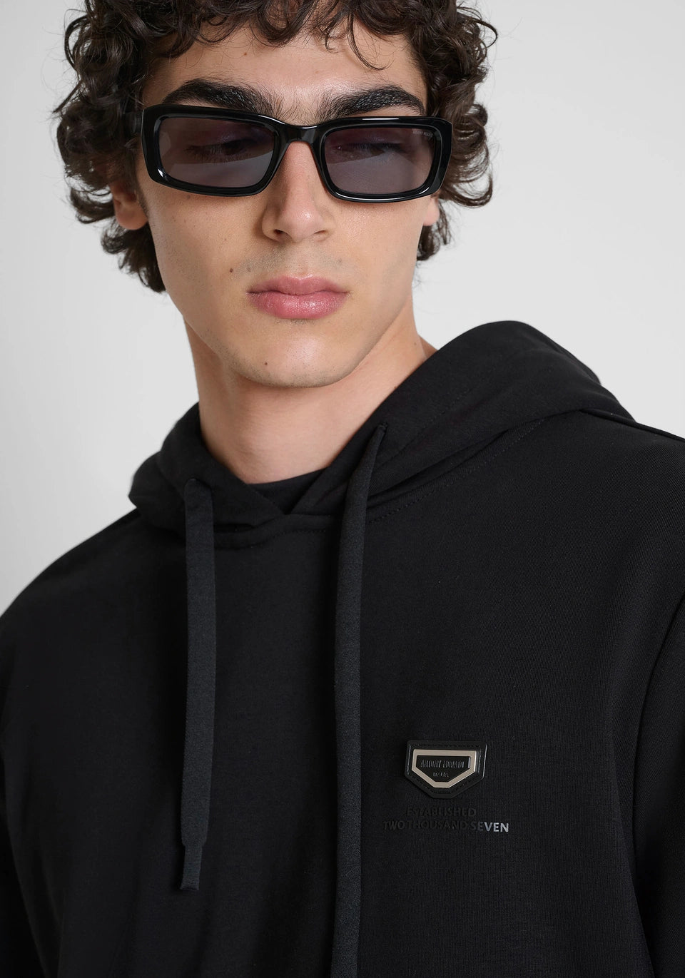 Black relaxed-fit hoodie in cotton fleece with metal plate on heart